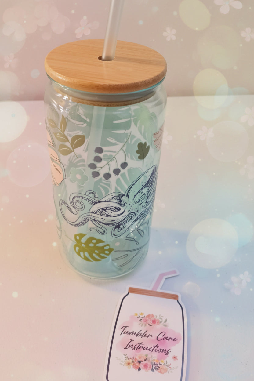 Tumbler with bamboo lid and straw on a white surface, accompanied by a tag.