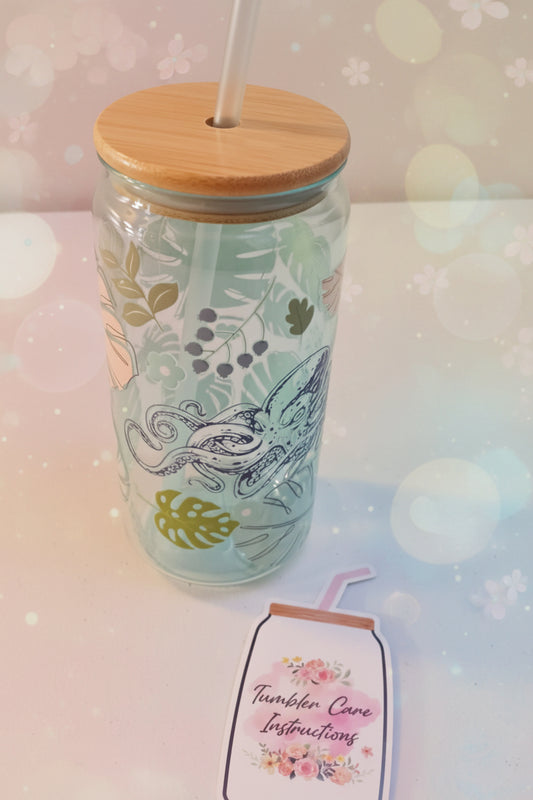 Tumbler with bamboo lid and straw on a white surface, accompanied by a tag.