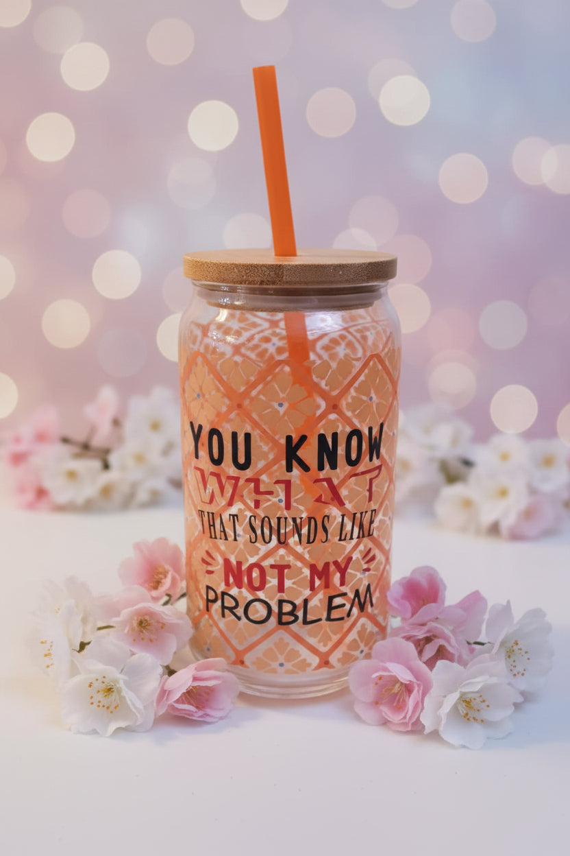 Tumbler with a wooden lid and straw, featuring text, on a white surface with a tag in the foreground.