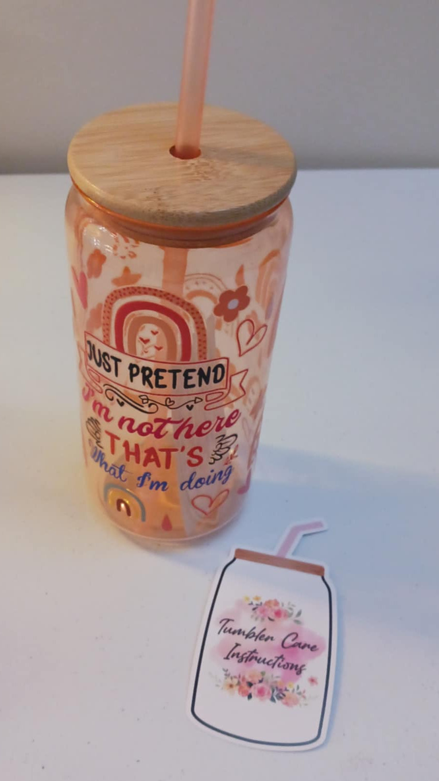 Tumbler with a wooden lid and straw on a white surface
